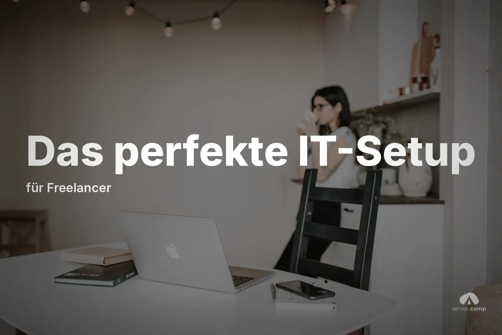Freelancerin bei der Kaffeepause im Homeoffice, auf dem Tisch Laptop, Smartphone und Bücher – der Arbeitsplatz, an dem der ganze Freelancer-Stack zusammenläuft