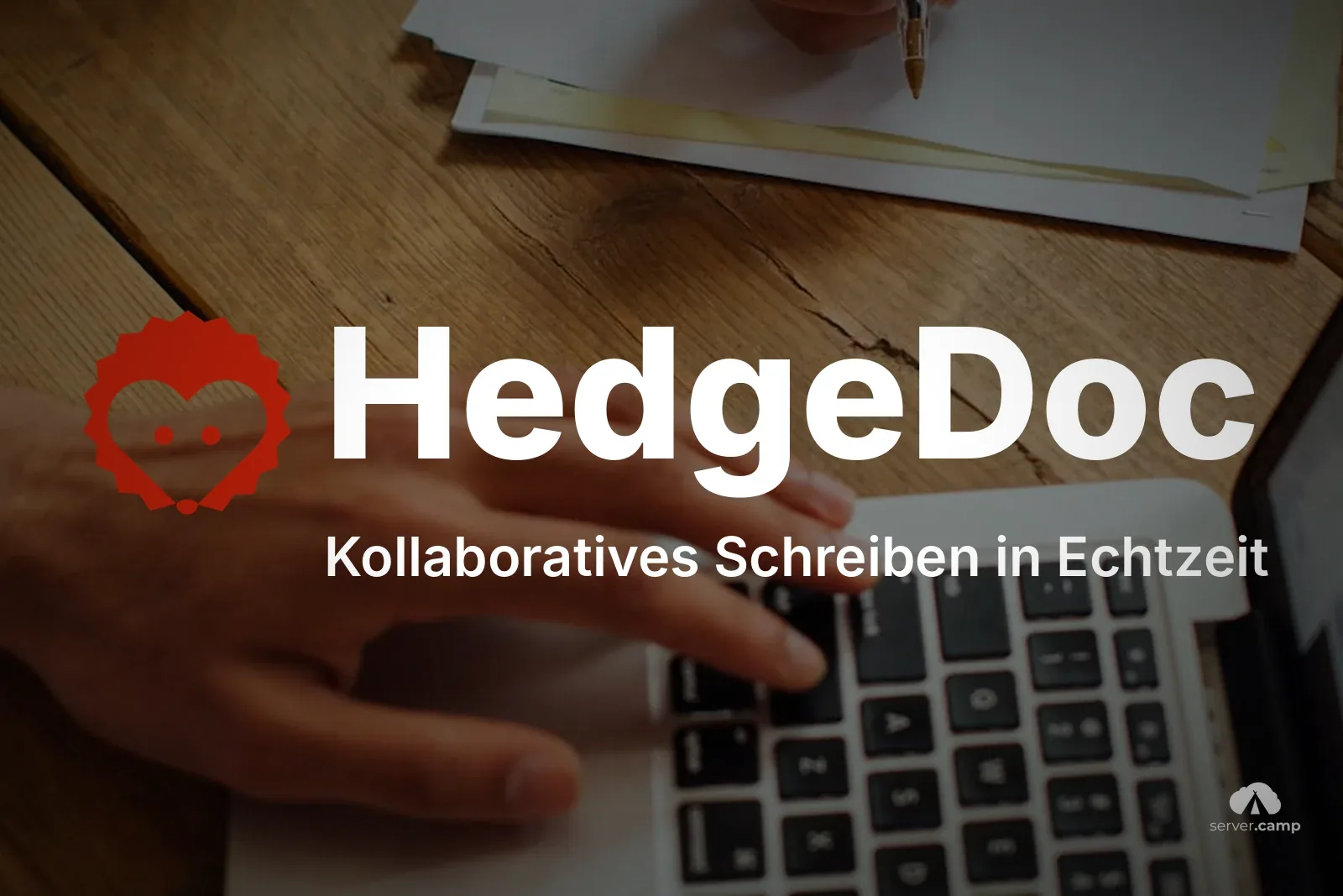 Hände an einer Laptop-Tastatur auf einem Holzschreibtisch, daneben beschriebene Blätter – gemeinsam schreiben mit HedgeDoc statt mit Google Docs